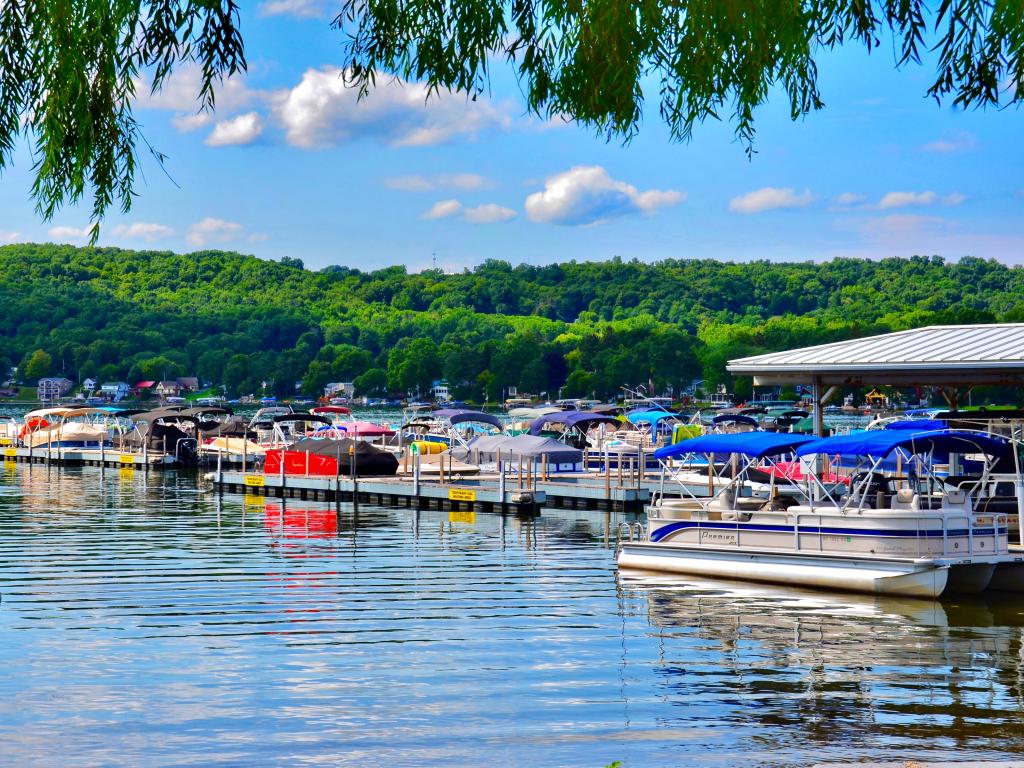 Summer scene, with sunny and blue sky, along the harbor on Keuka Lake, with many luxury boats docked there. 