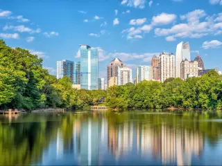 Atlanta, Georgia, USA with midtown city skyline in the distance and the park and lake in the foreground. 