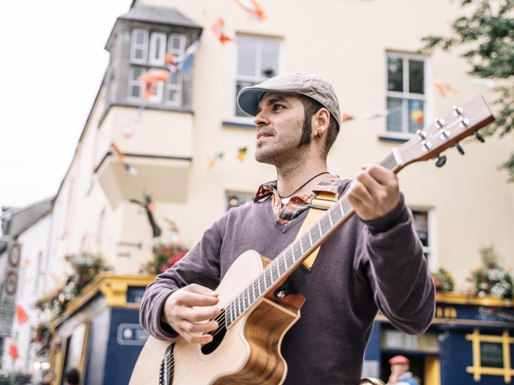 Street performer man playing the guitar in the Galway street. Ireland