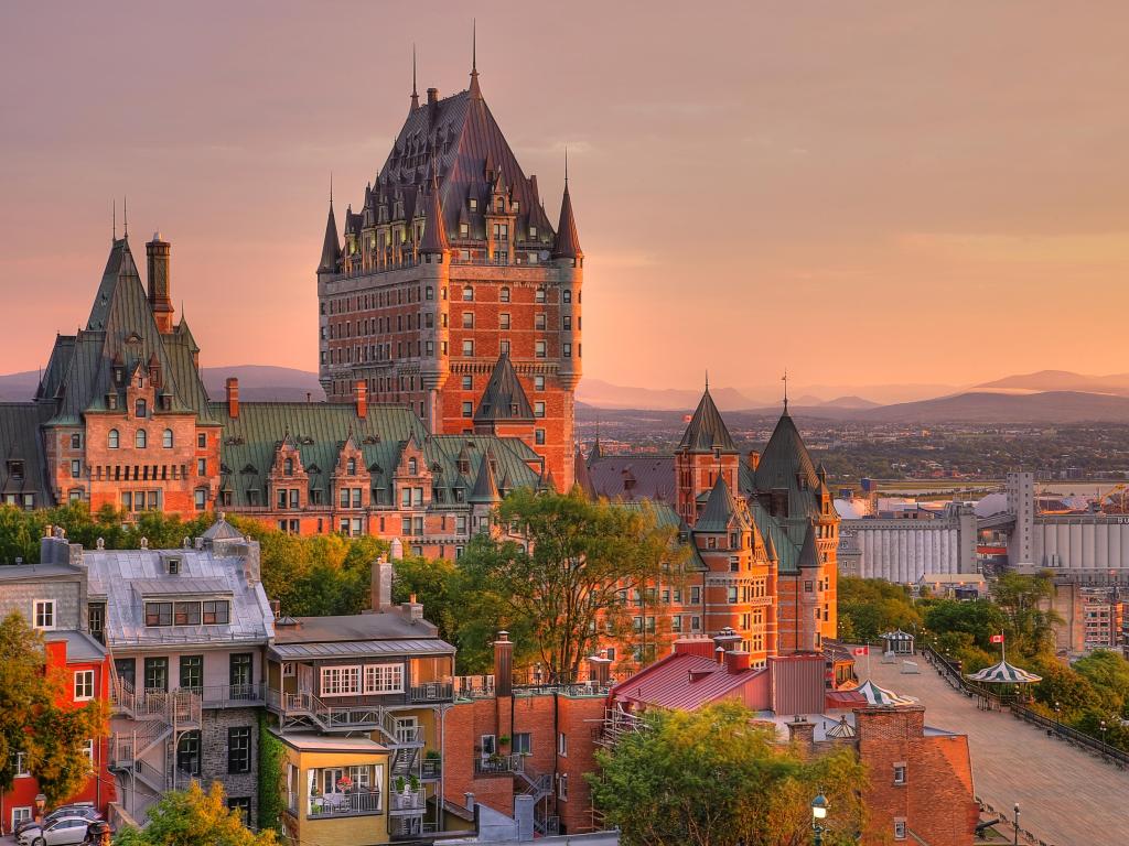 Old Quebec City, Quebec, Canada taken at Frontenac Castle in Old Quebec City in the beautiful sunrise light with hills in the distance and colorful buildings in the foreground. 