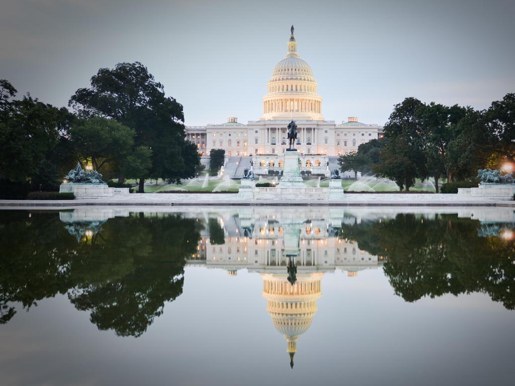 Washington DC, USA taken with the US Capitol Building in the background and reflected in the water in the foreground, taken just after sunset.