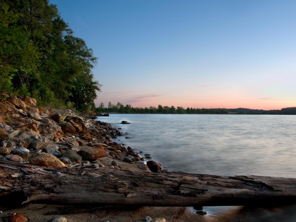 Lake Hartwell in Clemson, SC, USA with a view of the rocky beach at sunset.