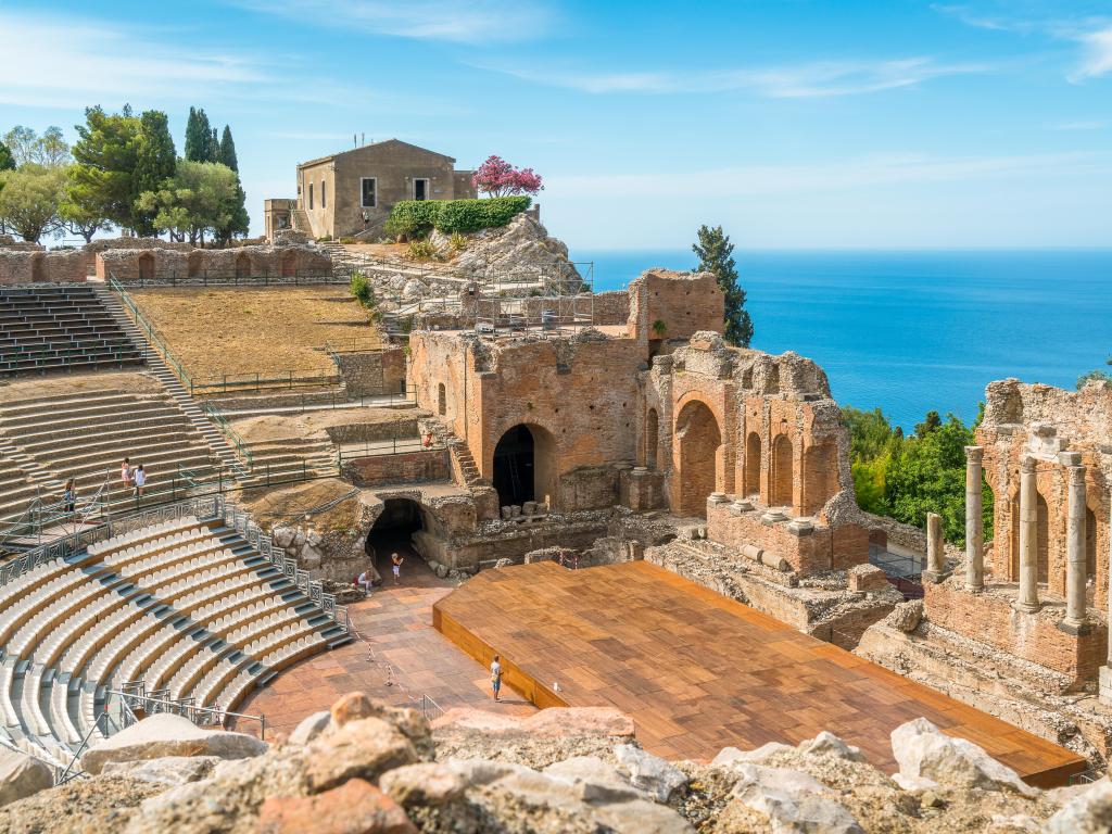 Ruins of the Ancient Greek Theater in Taormina on a sunny summer day with the Mediterranean Sea. Province of Messina, Sicily, southern Italy.