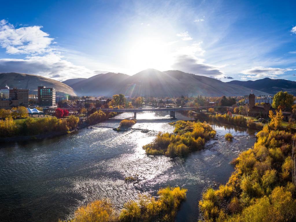 Missoula, Montana, USA taken as an aerial shot at morning with the Higgins Street Bridge and river in the foreground, mountains in the distance on a sunny clear day.