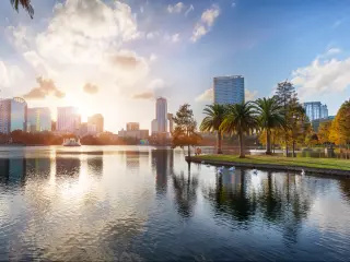Orlando, Florida, USA taken at sunset at Lake Eola Park with water fountain and city skyline on a sunny day.