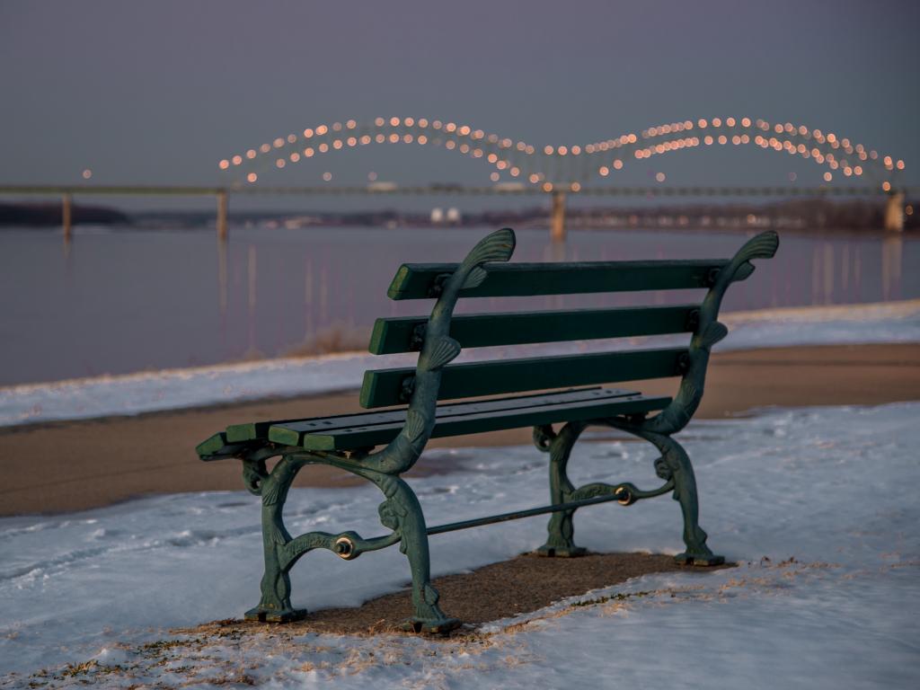 A bench in the Tom Lee Park in Memphis along the Mississippi River surrounded by snow on a cold January morning