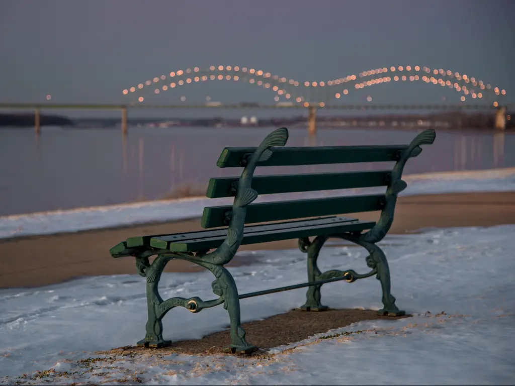 A bench in the Tom Lee Park in Memphis along the Mississippi River surrounded by snow on a cold January morning