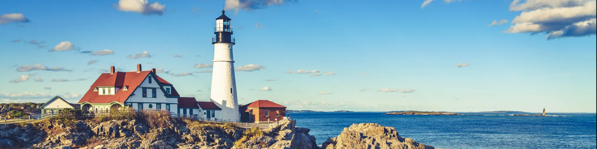 Portland, Maine, USA with a scenic view of the historic Portland Head Light in Cape Elizabeth, Maine on a sunny day.