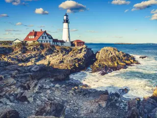 Portland, Maine, USA with a scenic view of the historic Portland Head Light in Cape Elizabeth, Maine on a sunny day.