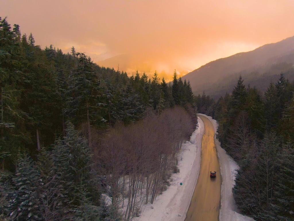 Cruising down Sea to Sky Highway. Tourists on a fun road trip across Canada drive along a scenic road leading across a large forest in British Columbia