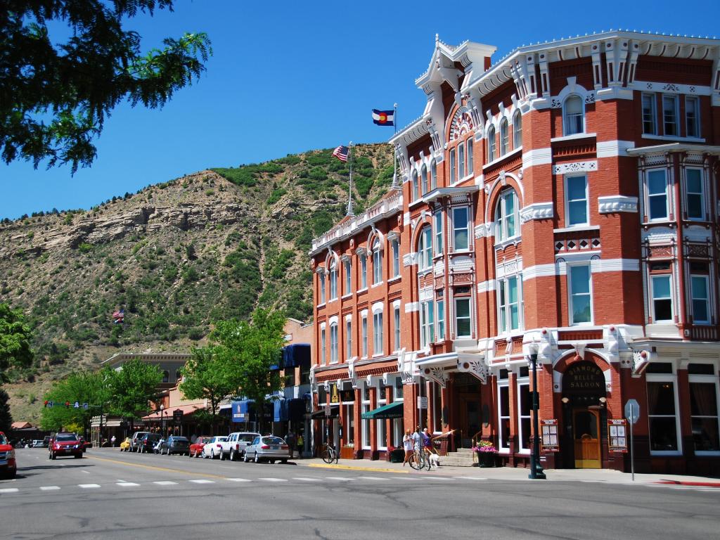 The historic red-brick Strater Hotel stands proud in Durango, Colorado on a sunny day with blue skies
