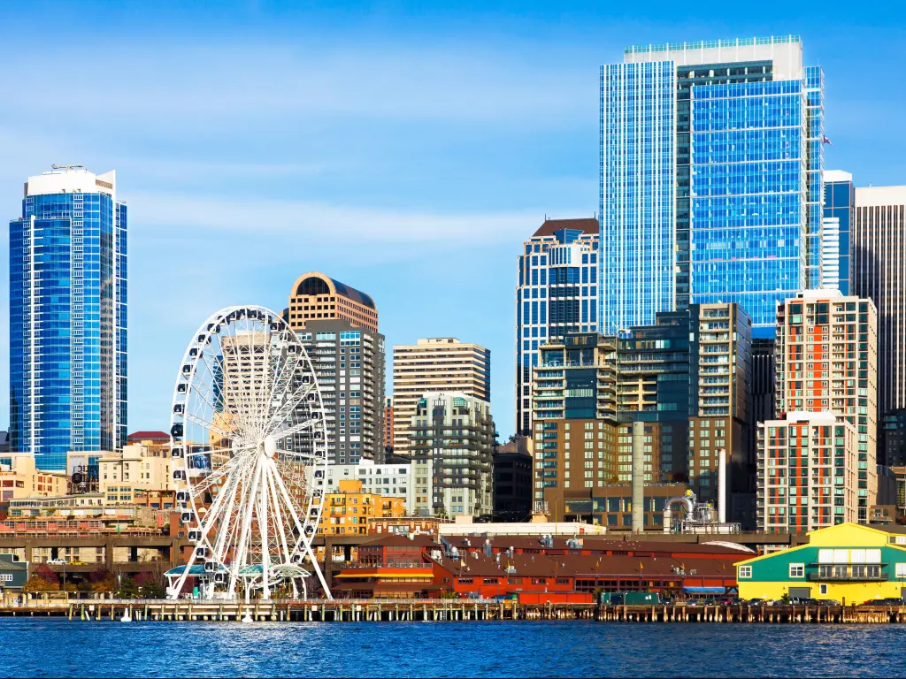 Seattle skyline and waterfront including the ferris wheel and sparkling high rise downtown buildings viewed from the bay on a bright clear day.