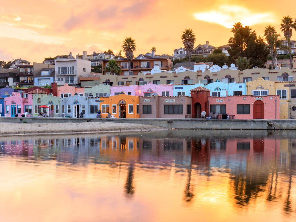 Santa Cruz, California with colourful buildings overlooking the sea and a sunset behind.