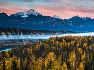 Anchorage, Alaska, USA with a dramatic autumn sunrise in the Chugach mountain range surrounded by colorful autumn foliage in Alaska.