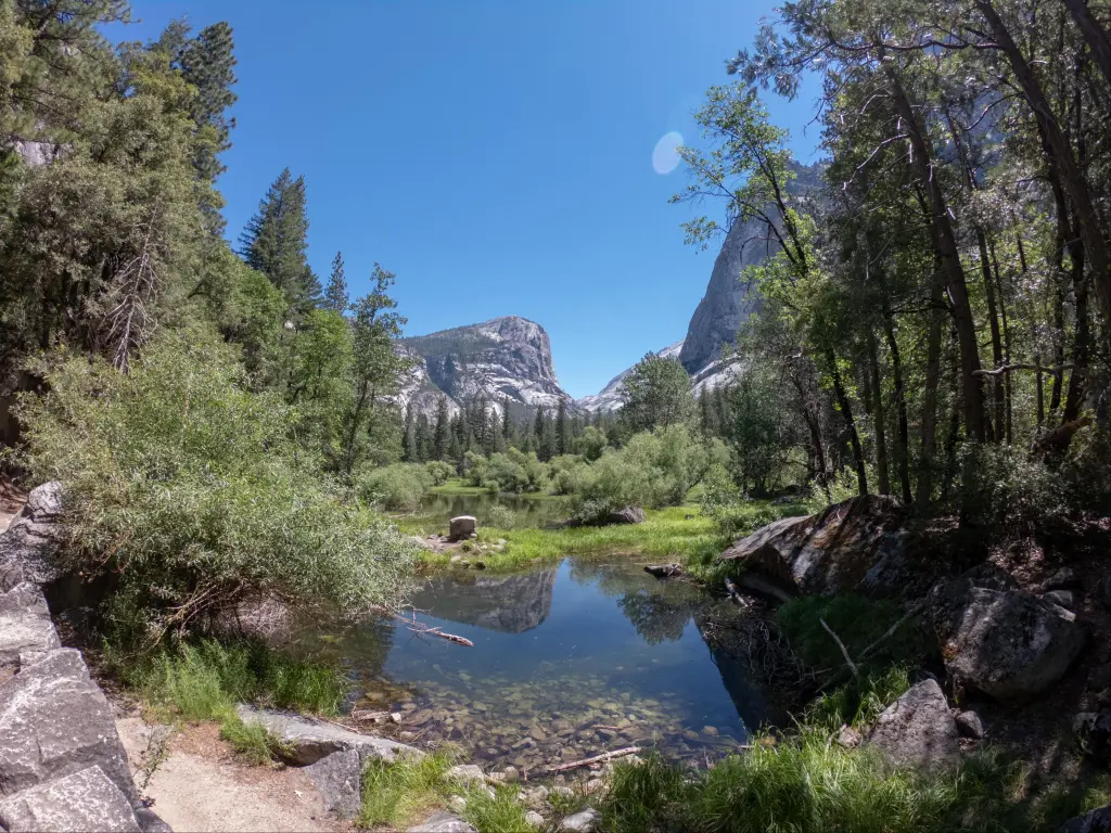 Mirror Lake in foreground, surrounded by forests and views of North Dome and Half Dome 