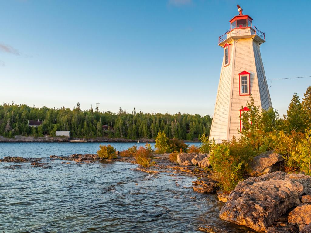 Big Tub Harbour in Tobermory, home to a white lighthouse and rocky shore on a sunny summer day