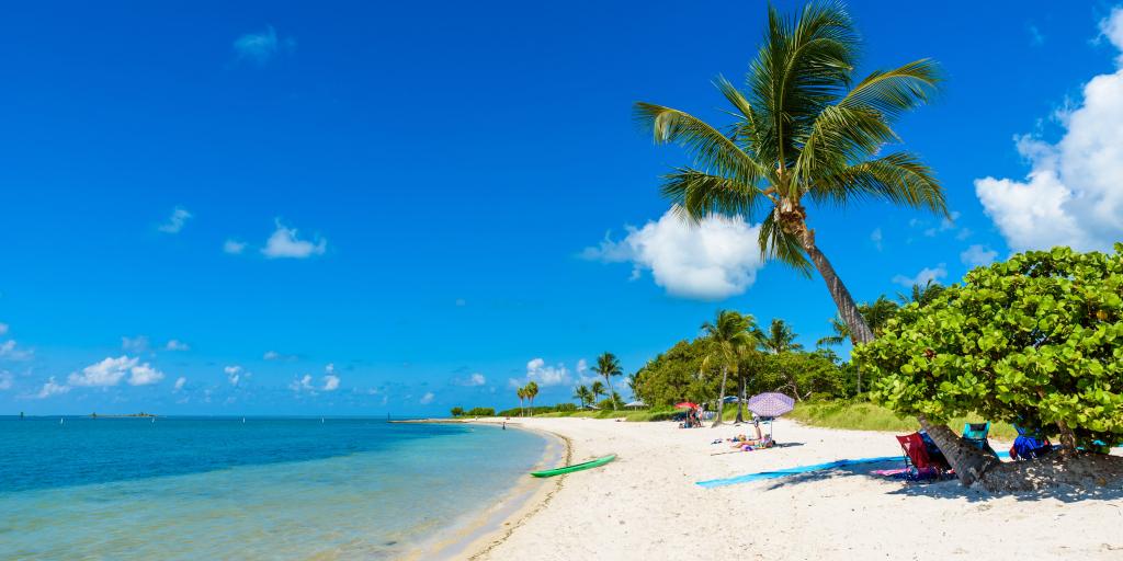 The white sand Sombrero Beach with palm trees and people sunbathing on Marathon island, Florida, USA. 