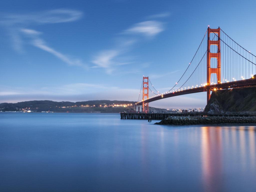 San Francisco, USA taken at the Golden Gate Bridge at sunset with lights in the distance. 