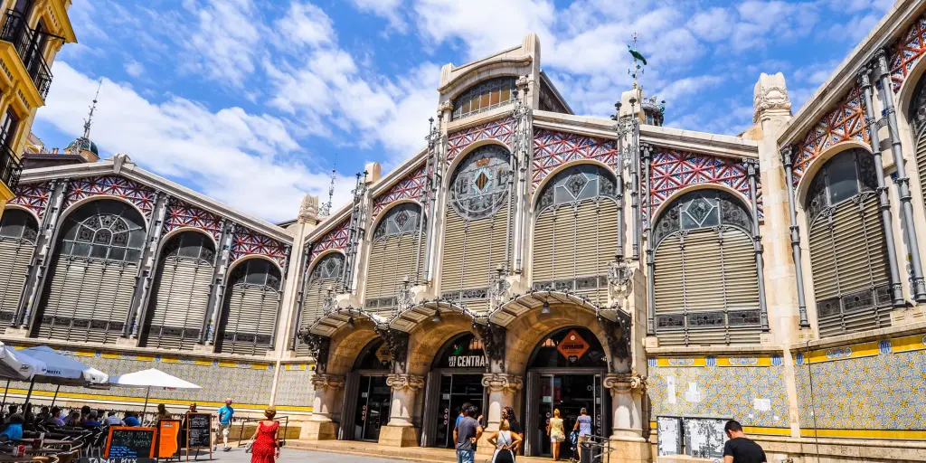 The outside of the Mercado Central in Valencia, Spain, with a pink tiled exterior and arched windows