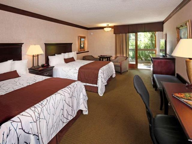 Spacious, modern bedroom at Best Western Plus Yosemite, a large suite with two double beds, desk and balcony
