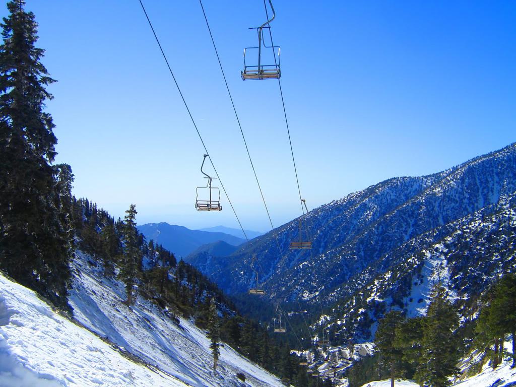 Chair lifts going up Mt. Baldy, California on a winter day with blue skies