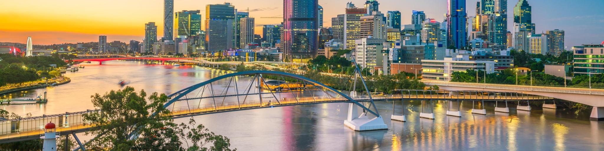 Brisbane, Australia at twilight with the city skyline in the background and the Brisbane river in the foreground. 