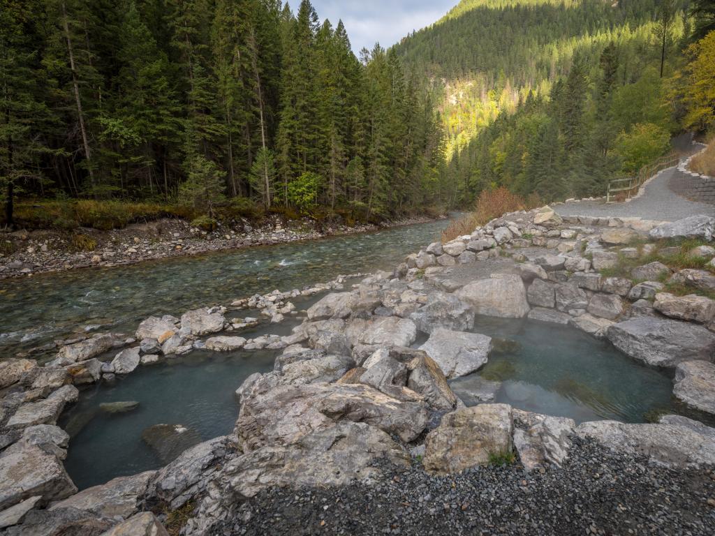 Natural hot springs pools, surrounded with rocks among a forest