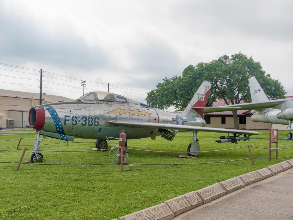 A vintage plane on display outside on the glass as a part of the museum exhibit