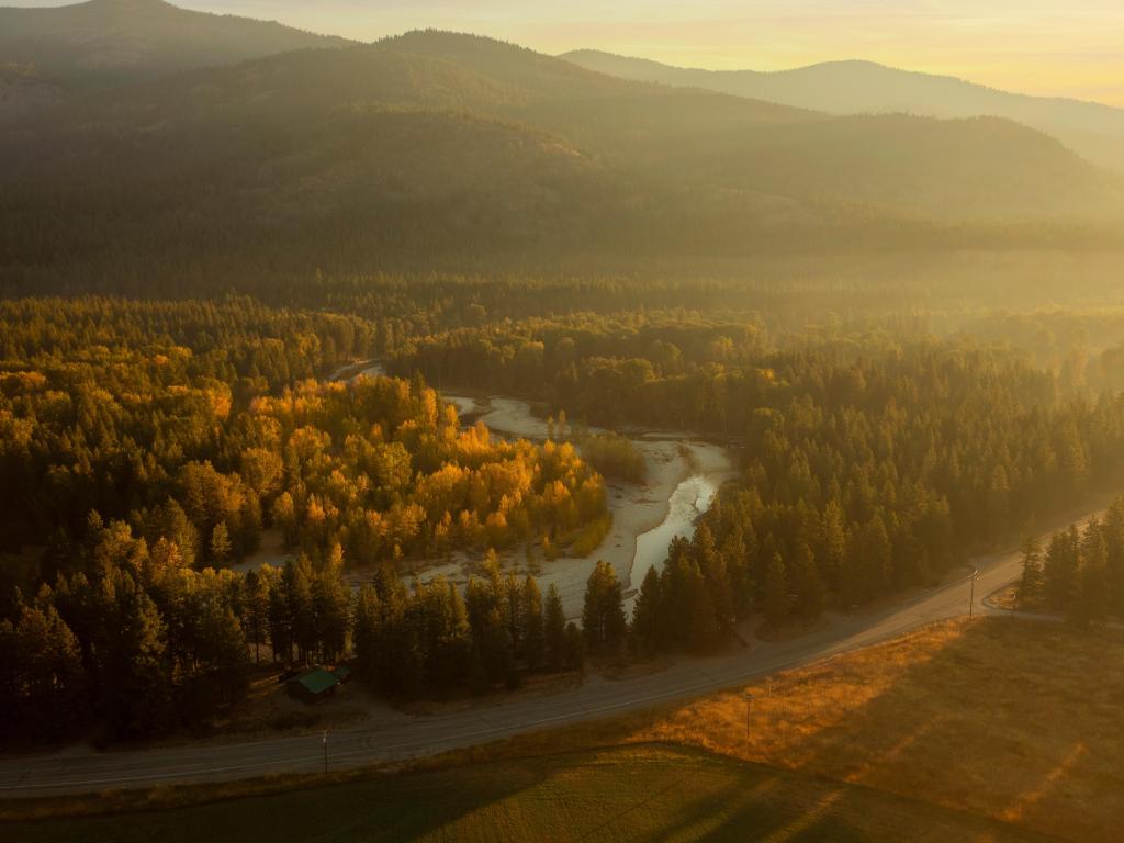 Methow Valley, Mazama, Washington, USA taken during a misty fall morning over the Methow River Near Mazama, Washington. Aerial drone view at sunrise of the historic Methow Valley with colorful views of the aspen trees changing to their autumnal colors.