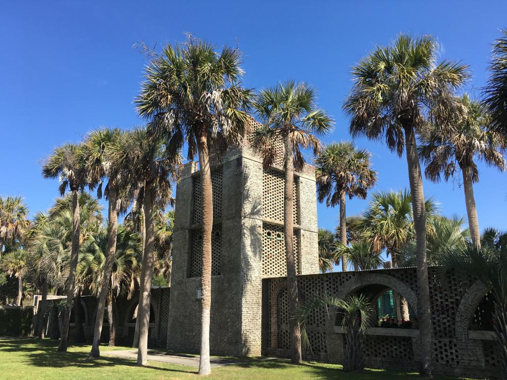 Historic castle in Huntington Beach State Park surrounded by palm trees on a sunny day