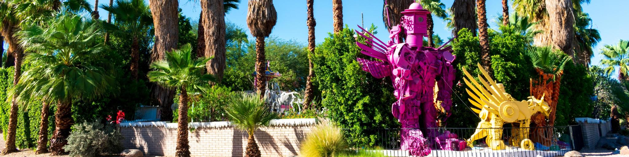 Bright pink and yellow Robolights artwork sculpture installation, surrounded by palm trees, Palm Springs, California