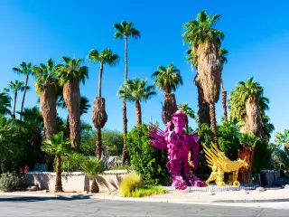 Bright pink and yellow Robolights artwork sculpture installation, surrounded by palm trees, Palm Springs, California