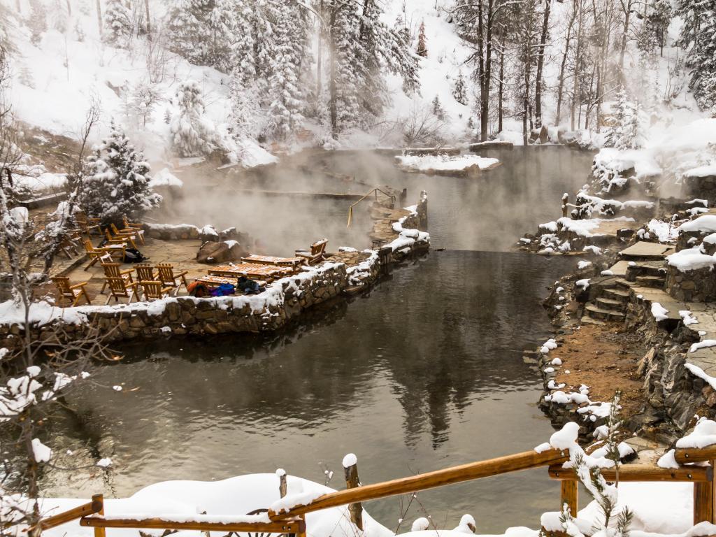 Natural hot springs in winter after freshly fallen snow with steam rising