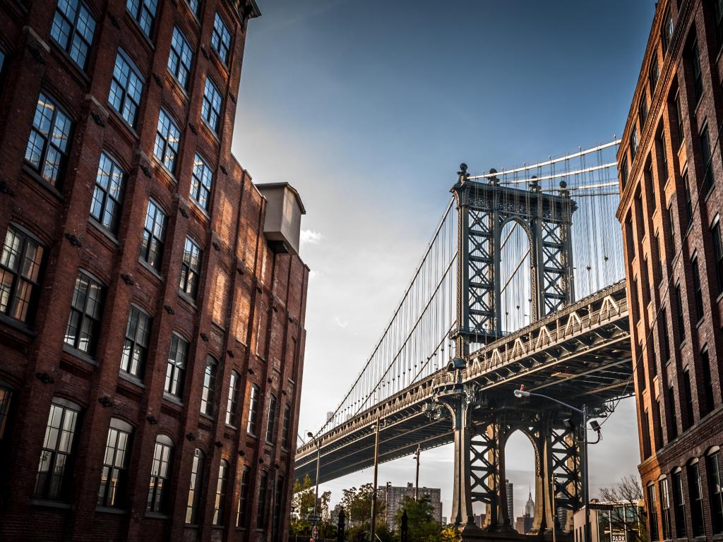 Bridge seen from a narrow alley enclosed by two brick buildings on a sunny day in summer