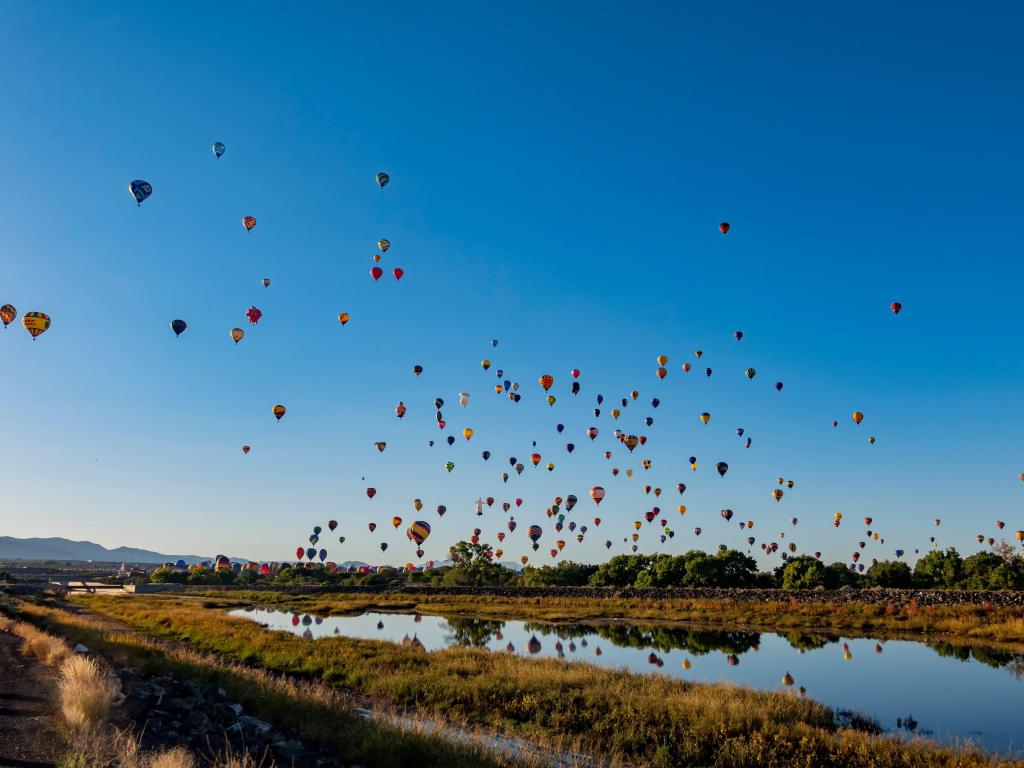 Albuquerque, New Mexico, USA with a morning view of the famous Albuquerque International Balloon Fiesta event taken on a clear sunny day above a river.