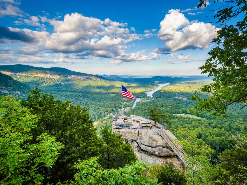 Chimney Rock State Park, North Carolina, USA with a view of Chimney Rock and Lake Lure on a sunny day.