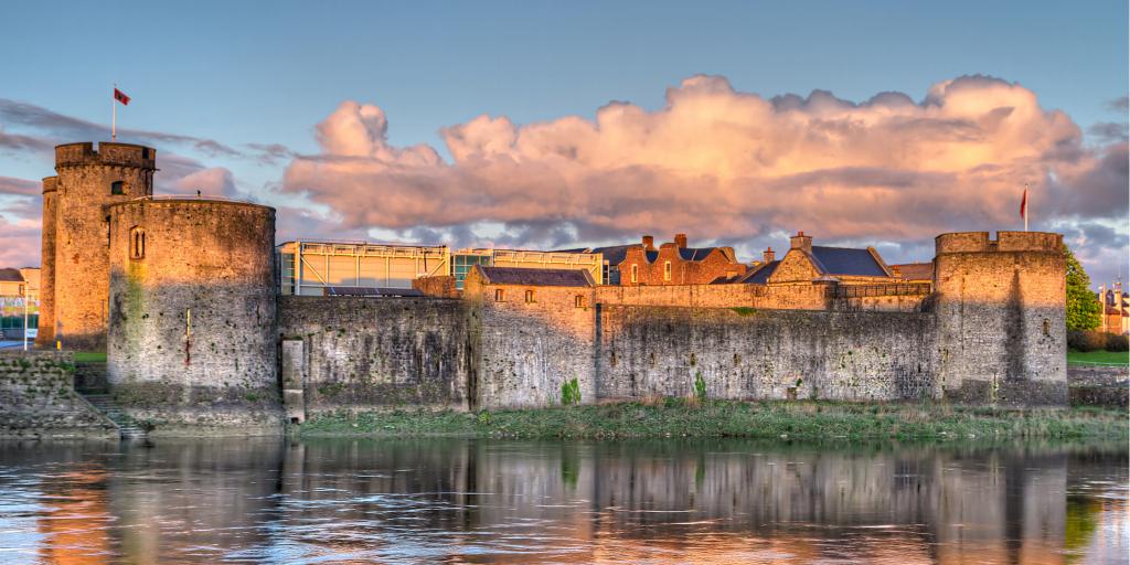 Pink light from the sun lights up King John's Castle in Limerick, Ireland