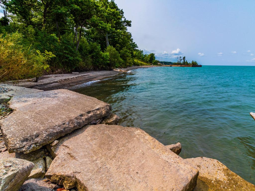 Lake Erie, Ohio, USA with the coastline in the foreground and taken at Rubes Landing on a sunny day, trees leading into the distance. 