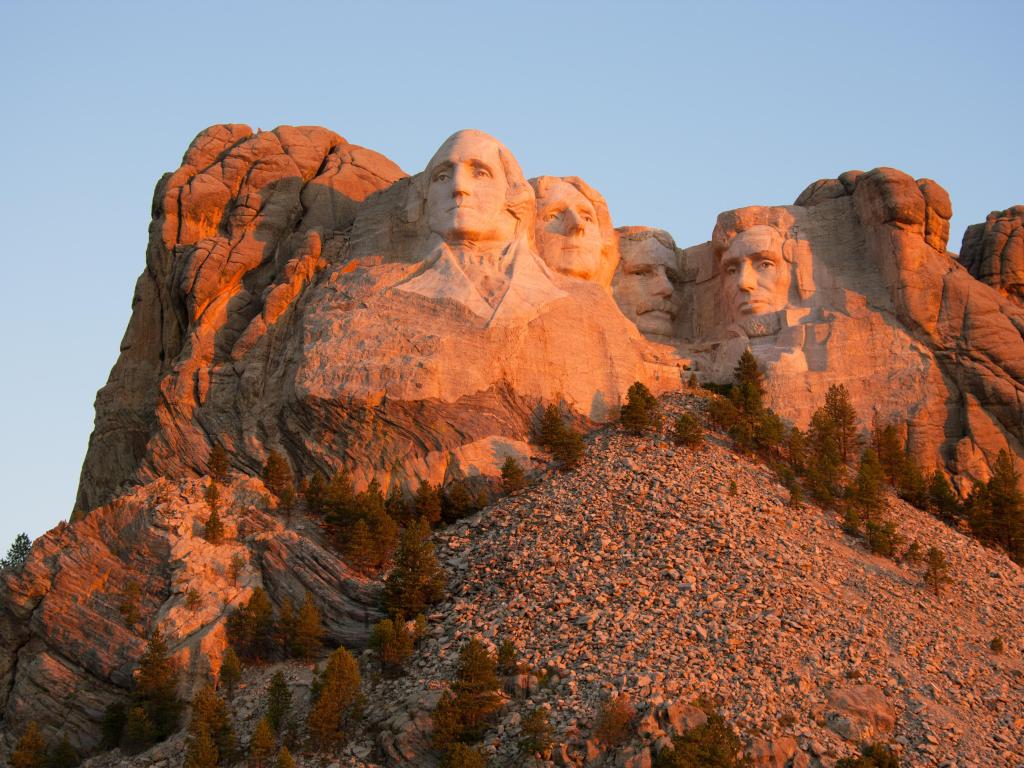 Mount Rushmore bathed in the orange glow of sunset