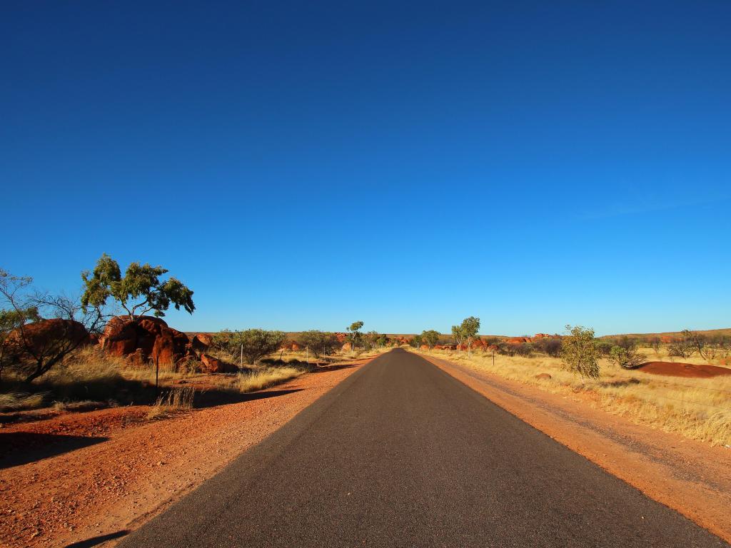 tarmac road through red dirt outback landscape