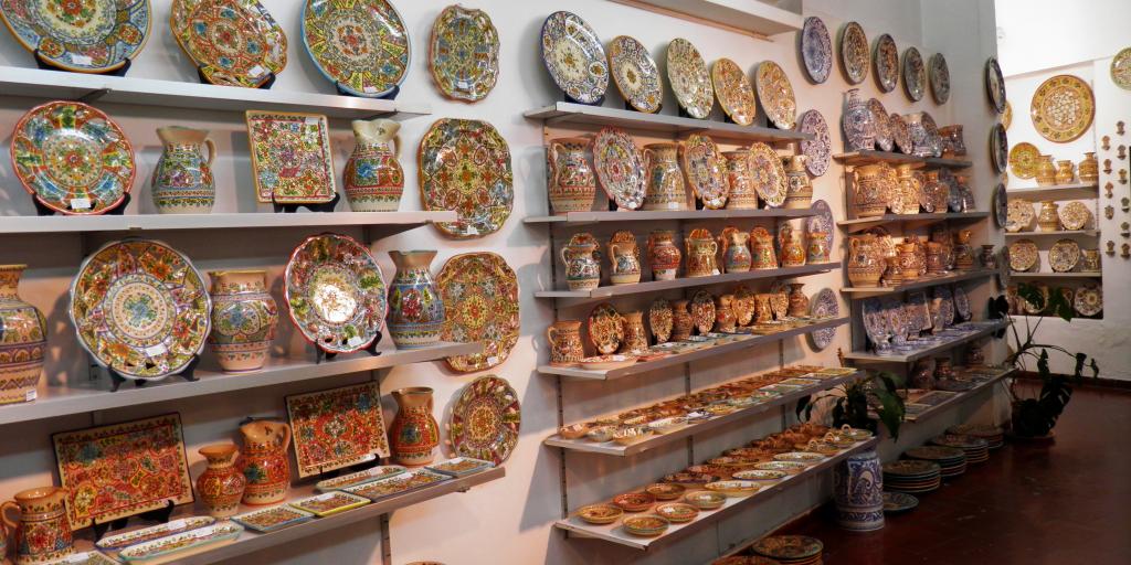 Plates and vases line the shelves inside a ceramics shop in Seville, Spain