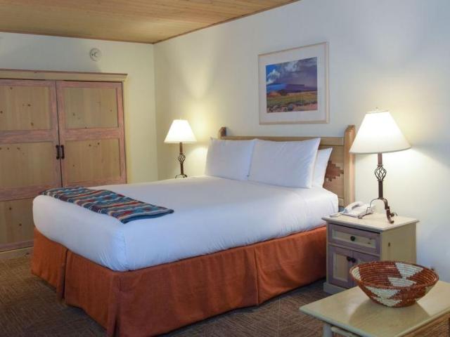 Traditional, rustic, decor with large bed and wooden furniture, in deluxe room at Inn on the Alameda, Santa Fe