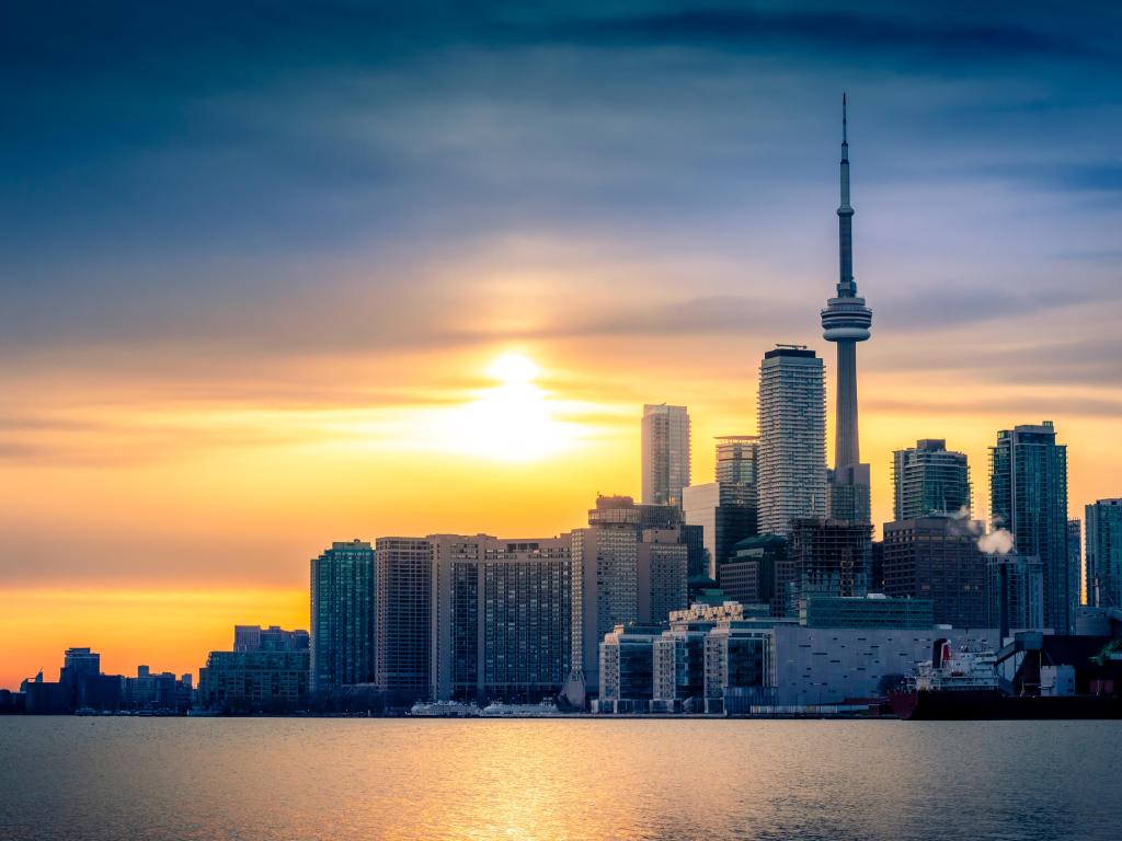 High rise buildings of Toronto downtown viewed across Lake Ontario in gold sunset light