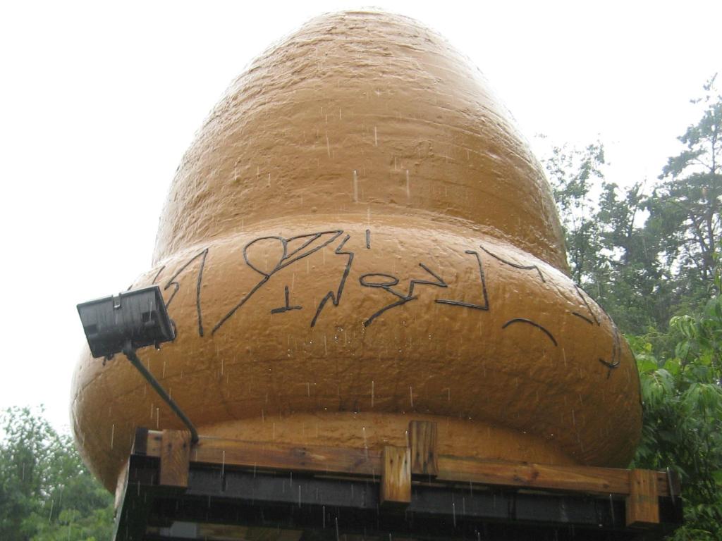 The acorn-shaped UFO statue in Kecksburg, with inscriptions written on it. Photo taken on a rainy day