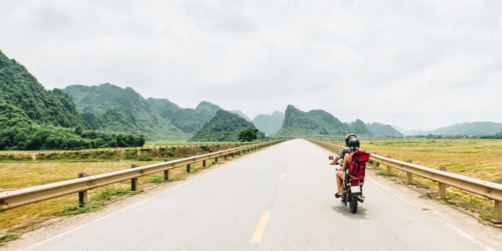 Female motorcyclist drives down a road in Vietnam