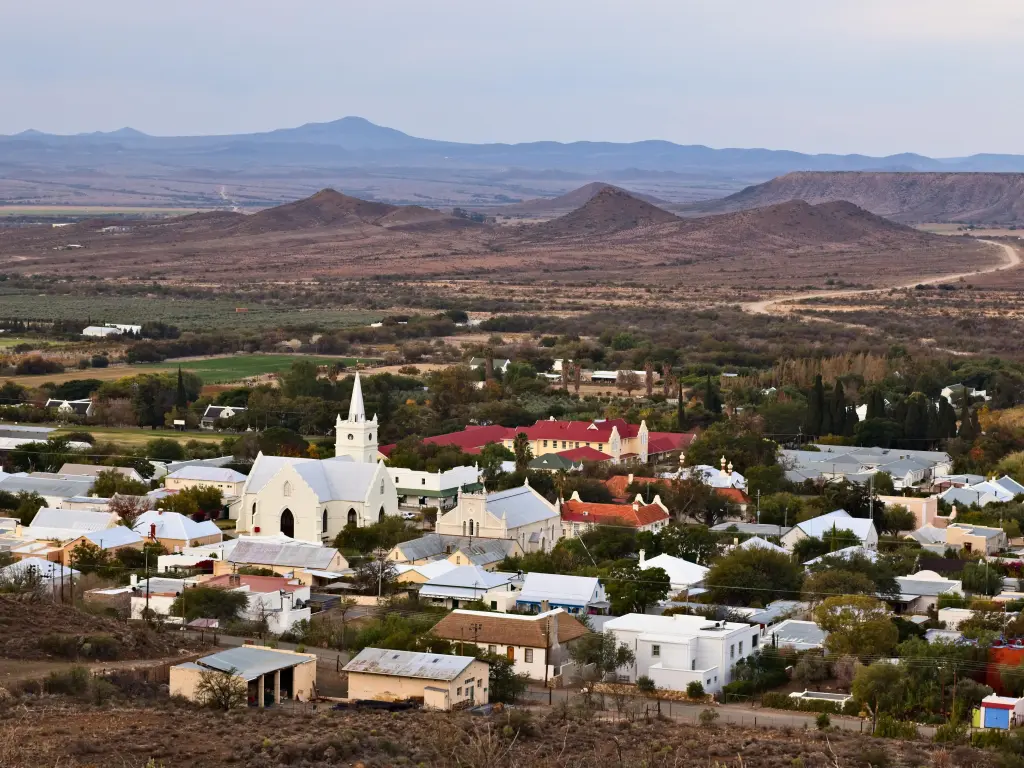 Aerial photo of the charming town with hills in the background on a cloudy day