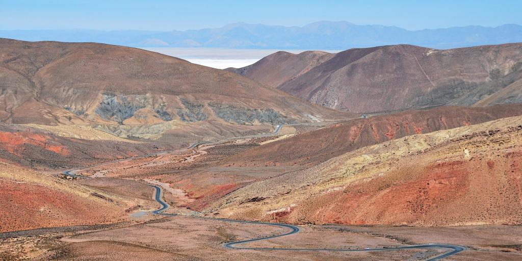 A view of the Route 52 road, Argentina, weaving through rust red mountains and desert.