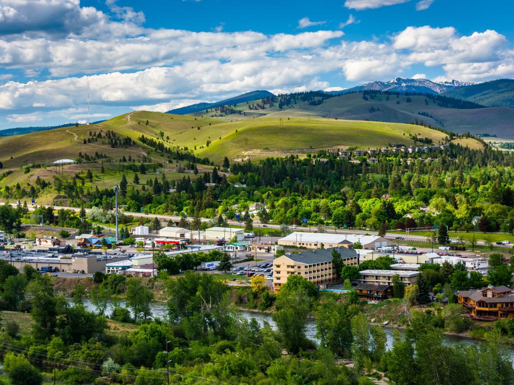 Missoula, Montana, USA taken from Mount Sentinel with the city in the foreground and trees and hills in the distance on a sunny day.