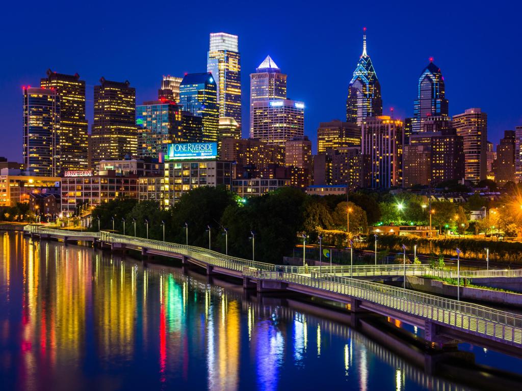 Philadelphia, Pennsylvania, USA with the city skyline and Schuylkill River at night, seen from the South Street Bridge.