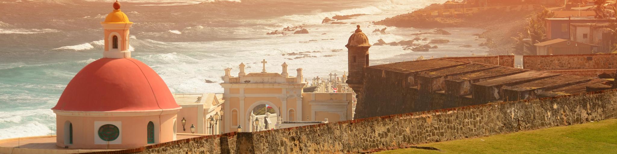 Old San Juan in Puerto Rico, ocean view with buildings in red tone during sunset